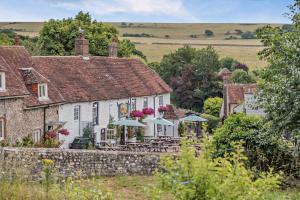 una casa con tavoli e ombrelloni di fronte di Cub Bedroom Two a Eastdean