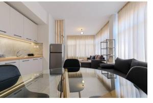 a kitchen and a living room with a glass table at Ladadika Vibes Apartments 2 in Thessaloniki