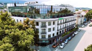a large white building on a city street with cars at Holiday Inn Telavi by IHG in Telavi