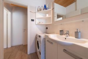 a bathroom with a sink and a washing machine at Appartamento Jubilant in Comano +22 photos