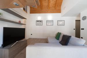 a living room with a couch and a flat screen tv at Appartamento Jubilant in Comano