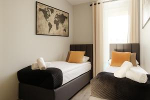 a bedroom with two beds and a chair at Prestige Apartaments 79 in Wrocław +76 photos