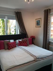 圣沃尔夫冈Schafberg Apartment的卧室内的一张带红色和白色枕头的床