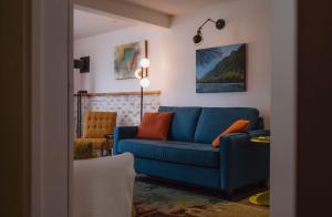 a living room with a blue couch and a chair at eARTh studios GallerySuite in Nelson