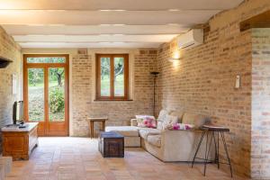 a living room with a couch and a brick wall at Villa Lucia in Barchi