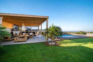 a villa with a patio and a swimming pool at Petra Luxury Villa in Heraklio Town