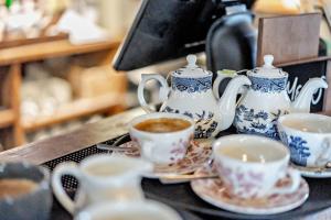 eine Gruppe von Tassen und Untertassen auf einem Tisch in der Unterkunft Cub Bedroom One in Eastdean + 13 Fotos
