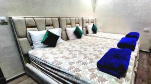 a large bed with blue cushions and pillows at Appart Ennakhil 4 avenue mohamed 6 in El Jadida