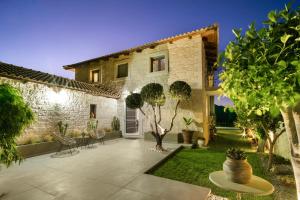 a courtyard of a house with trees and plants at Petra Luxury Villa in Heraklio Town