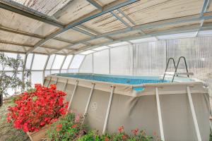 a hot tub in a greenhouse with flowers at Gîte Uncinatum - La Grange Du Logis in Villevieille