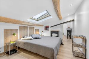 a bedroom with a large bed and a skylight at Gîte Uncinatum - La Grange Du Logis in Villevieille +24 photos