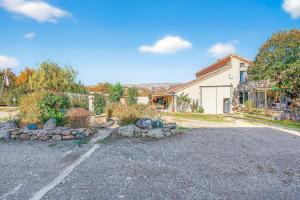 a house with a driveway in front of a building at Gîte Uncinatum - La Grange Du Logis in Villevieille