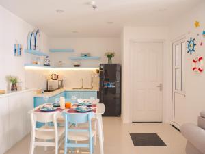 a kitchen with a table and chairs in a room at 2BR Luxury riverview - Melody of the Sea Monarchy in Da Nang