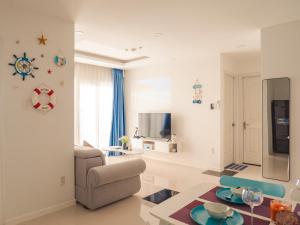 a living room with a chair and a television at 2BR Luxury riverview - Melody of the Sea Monarchy in Da Nang