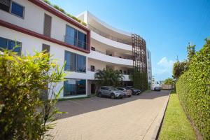 a building with cars parked in a parking lot at Legacy Square by QUAO REALTY in East Legon