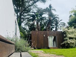 een huis met een houten hek in een tuin bij Posada Punta del Este in Punta del Este
