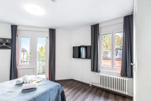 Una habitación blanca con una cama y una ventana en Delta City Hotels - Self check-in, en Zúrich