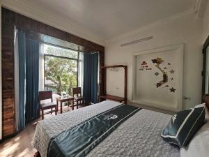 een slaapkamer met een bed en een groot raam bij The Green House Homestay in Ninh Binh