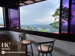 2 stoelen en een tafel in een kamer met ramen bij HC Helena in Filandia