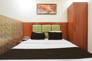 a bedroom with a large bed with a green headboard at Super Townhouse Kali Ghat Prayagraj Formerly Ramesh Palace in Prayagraj +22 photos