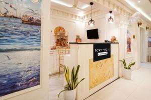 a room with a tv and paintings on the wall at Super Townhouse Kali Ghat Prayagraj Formerly Ramesh Palace in Prayagraj