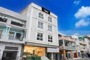 a white building with a sign on the side of it at Super Townhouse Kali Ghat Prayagraj Formerly Ramesh Palace in Prayagraj