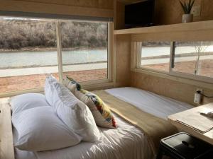 une chambre avec un lit avec des oreillers et une fenêtre dans l'établissement Luxury Tiny Home in Colorado, Ideal for Romantic Getaways to Grand Junction, à Grand Junction