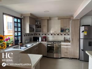 a kitchen with wooden cabinets and stainless steel appliances at HC Helena in Filandia