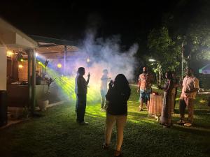 a group of people standing in front of a smoke trail at Thomasz Lodge 2 in Kandy