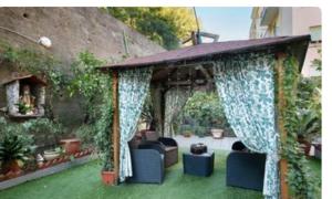 Un cenador con un sofá y sillas en un patio. en oparavisegenova, en Génova 2 fotos más