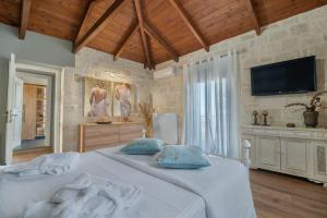 a bedroom with a bed with a tv on the wall at Petra Luxury Villa in Heraklio Town +23 photos