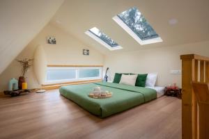 a bedroom with a large green bed with skylights at Lolo's by Raho - Loft Stay in Coorg in Ammatti +35 photos