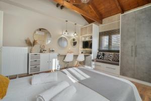 a bedroom with a large white bed and a kitchen at Petra Luxury Villa in Heraklio Town