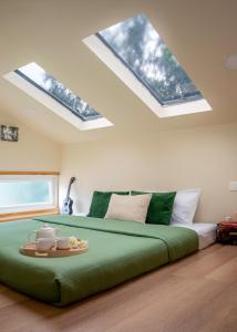 a bedroom with a large green bed with skylights at Lolo's by Raho - Loft Stay in Coorg in Ammatti