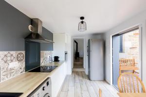 a kitchen with white walls and wooden floors at Gîte Kereliott in Lézardrieux +6 photos