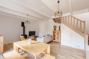 a living room with a wooden table and a staircase at Gîte Kereliott in Lézardrieux