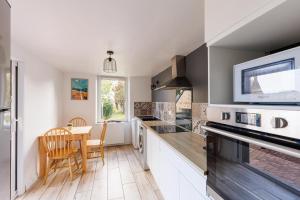 a kitchen with a table and a dining room at Gîte Kereliott in Lézardrieux