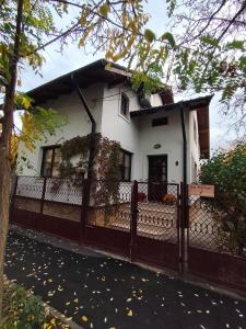 a white house with a fence in front of it at Casa Paul in Craiova