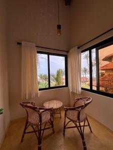 a room with two chairs and a table and two windows at Tahini and Friends Surf, Yoga & Wellness in Ahangama