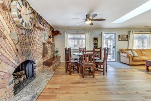 ein Wohnzimmer mit einem Steinkamin mit Tisch und Stühlen in der Unterkunft Pinetop-Lakeside Cabin, Walk to Woodland Lake Park in Pinetop-Lakeside