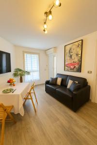 een woonkamer met een zwarte bank en een tafel bij Étoile Riviera - Studio 2P, Centre, Plages & Palais in Cannes +9 foto's