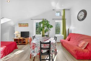 a living room with a red couch and a table at Gîte Mélano - La Grange du Logis in Villevieille