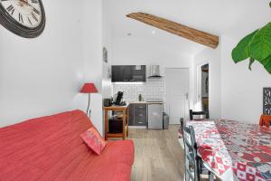 a bedroom with a bed and a clock on the wall at Gîte Mélano - La Grange du Logis in Villevieille