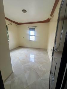 an empty room with a tile floor and a window at Antique Family Residence in Kitala