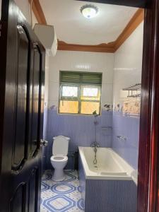 a blue and white bathroom with a tub and a toilet at Antique Family Residence in Kitala