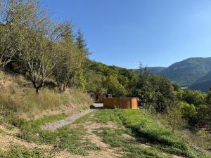 a dirt road with a building on the side of a hill at Chalet d hiver in Millau