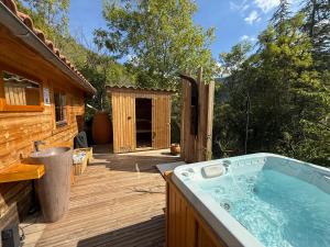 a hot tub on a deck next to a cabin at Chalet d hiver in Millau