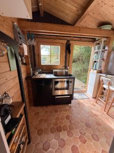 a kitchen in a tiny house with a stove at Chalet d hiver in Millau +2 photos
