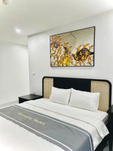 a bedroom with a bed with a painting on the wall at Tam Coc Armany Hotel & Sky Restaurant in Vũ Lâm