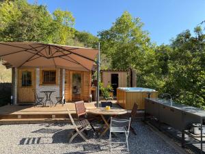 a patio with an umbrella and a table and chairs at Chalet d hiver in Millau